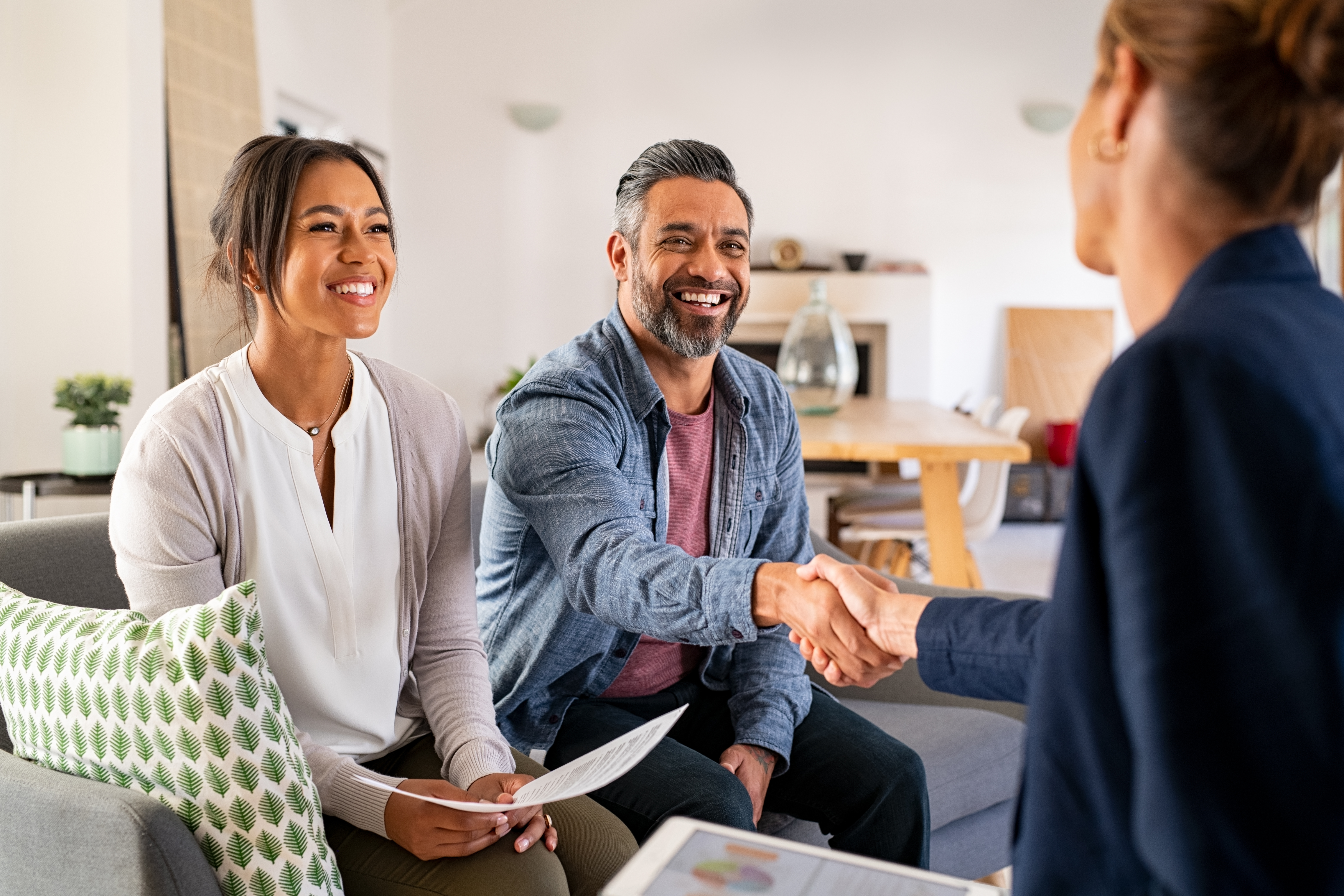 Happy couple shaking hands with advisor